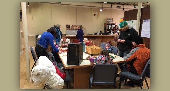 People gathering around a table inside the Chaska History Center