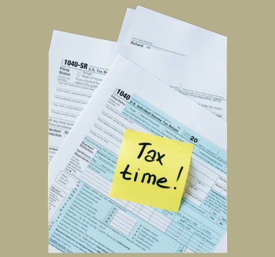 Tax forms with post-it note saying Tax Time!