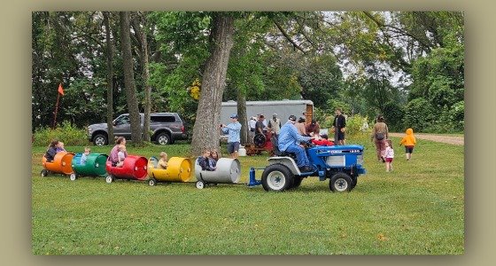 Tractor pulling cabs with kids in them at Fall at the Farm event