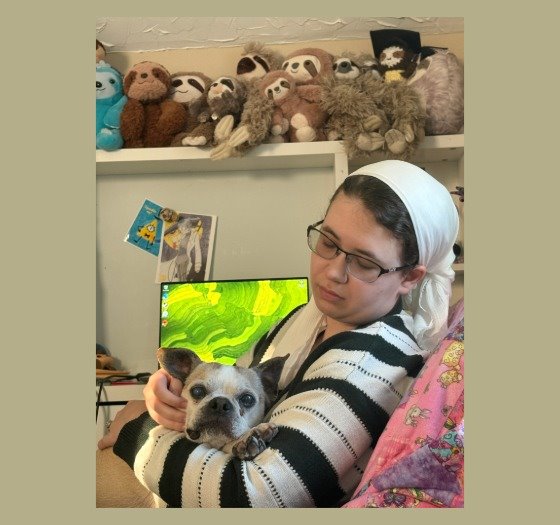 Amanda Ridek-Bernn holding dog, stuffed animals on shelf