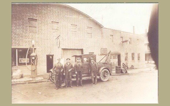 Men standing in front of car in front of Duwalter's Garage