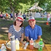 two people eating a picnic dinner in a park
