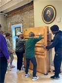 The Chaska/Chan high school wrestling team were helping move the furniture in preparation for the 2023 exhibit.